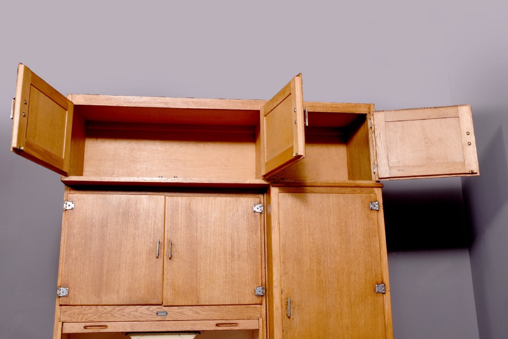 A tall oak Easiwork kitchen cabinet featuring multiple storage cupboards, drawers, an integrated enamel work surface, and an internal flour sifter mechanism. View III