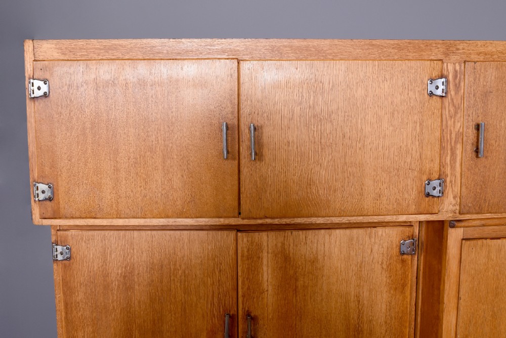 A tall oak Easiwork kitchen cabinet featuring multiple storage cupboards, drawers, an integrated enamel work surface, and an internal flour sifter mechanism. View IV