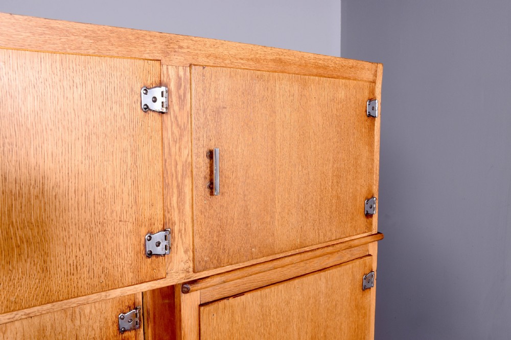 A tall oak Easiwork kitchen cabinet featuring multiple storage cupboards, drawers, an integrated enamel work surface, and an internal flour sifter mechanism. View V