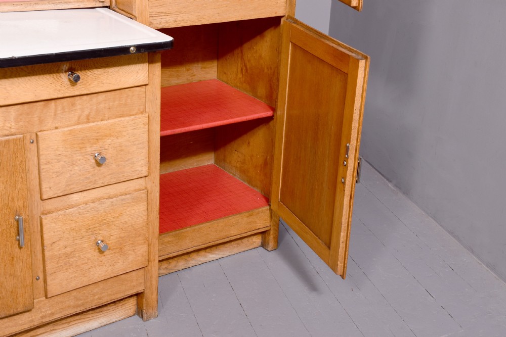 A tall oak Easiwork kitchen cabinet featuring multiple storage cupboards, drawers, an integrated enamel work surface, and an internal flour sifter mechanism. View VIII