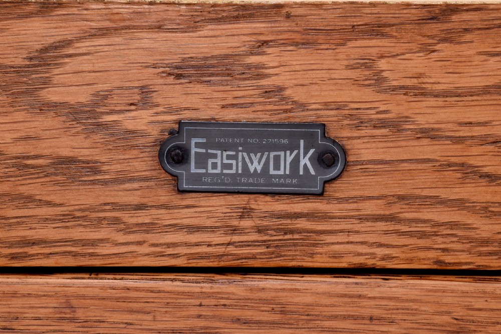 A tall oak Easiwork kitchen cabinet featuring multiple storage cupboards, drawers, an integrated enamel work surface, and an internal flour sifter mechanism. View X