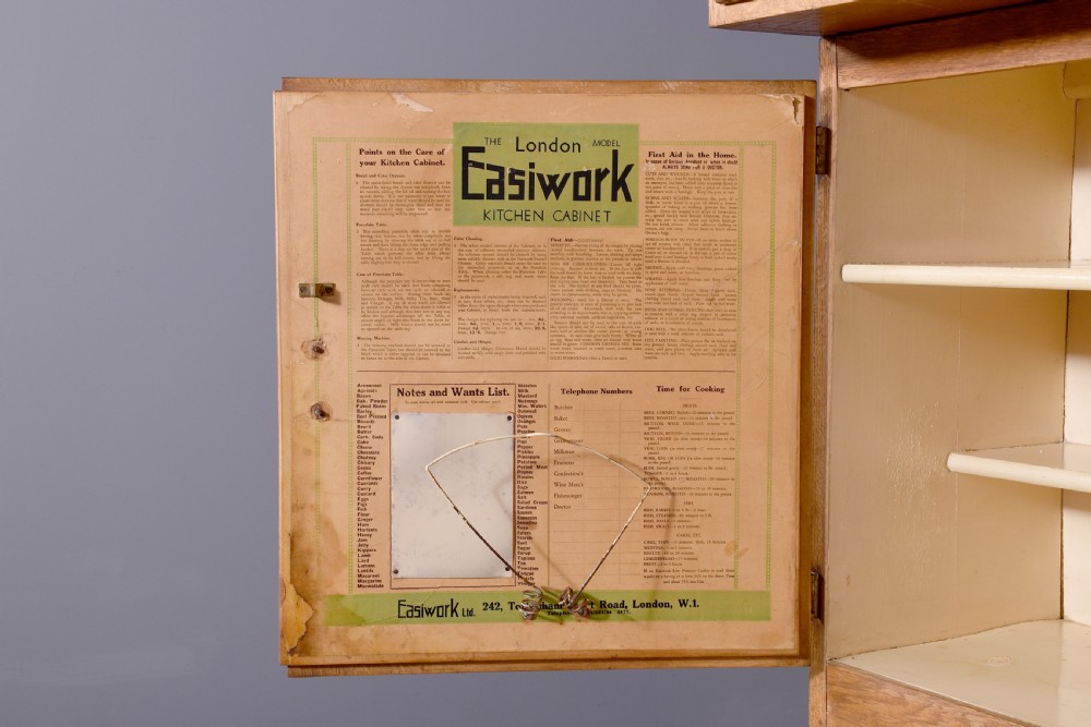 A tall oak Easiwork kitchen cabinet featuring multiple storage cupboards, drawers, an integrated enamel work surface, and an internal flour sifter mechanism. View XI