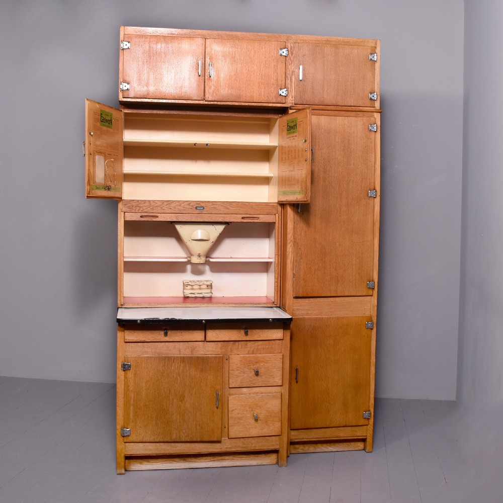 A tall oak Easiwork kitchen cabinet featuring multiple storage cupboards, drawers, an integrated enamel work surface, and an internal flour sifter mechanism. View XIII