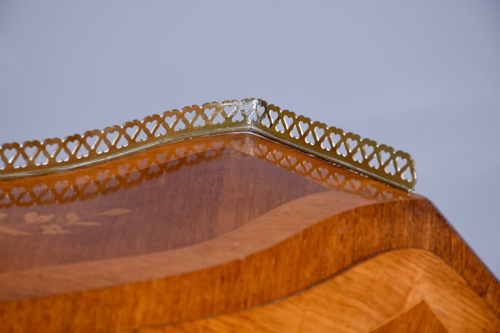 A small French Louis XV style slope-front writing desk featuring floral marquetry inlays, cabriole legs with brass mounts, and a brass gallery rail. View V