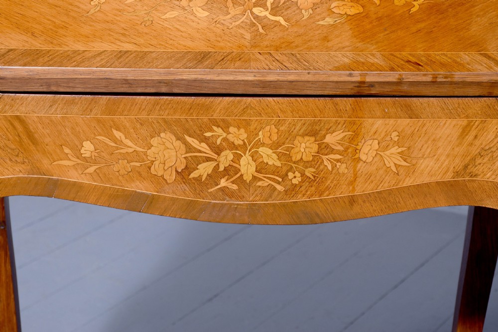 A small French Louis XV style slope-front writing desk featuring floral marquetry inlays, cabriole legs with brass mounts, and a brass gallery rail. View VI