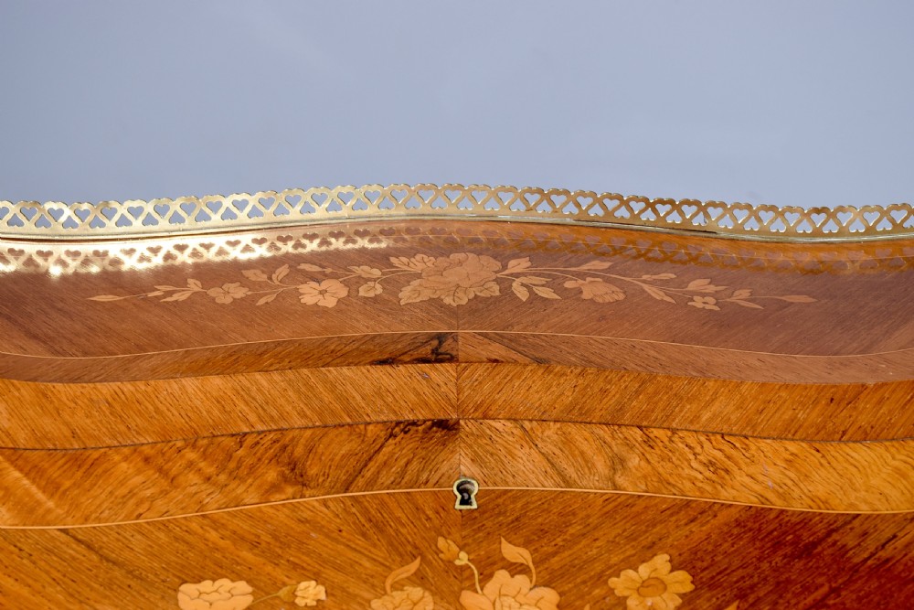 A small French Louis XV style slope-front writing desk featuring floral marquetry inlays, cabriole legs with brass mounts, and a brass gallery rail. View XVII