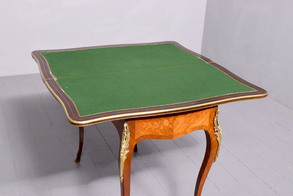 A Louis XV style French fold-over card table featuring warm brown veneer with floral marquetry inlay, cabriole legs, and gilt-bronze mounts. View VIII