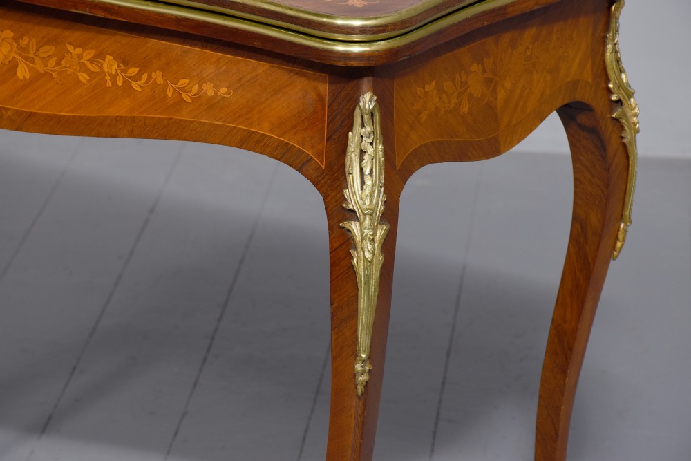 A Louis XV style French fold-over card table featuring warm brown veneer with floral marquetry inlay, cabriole legs, and gilt-bronze mounts. View IX