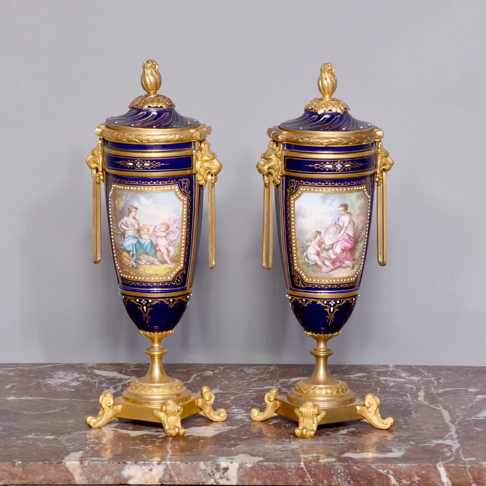 Pair of Sevres or Sevres style hand - decorated cobalt blue porcelain vases with ormolu mounts