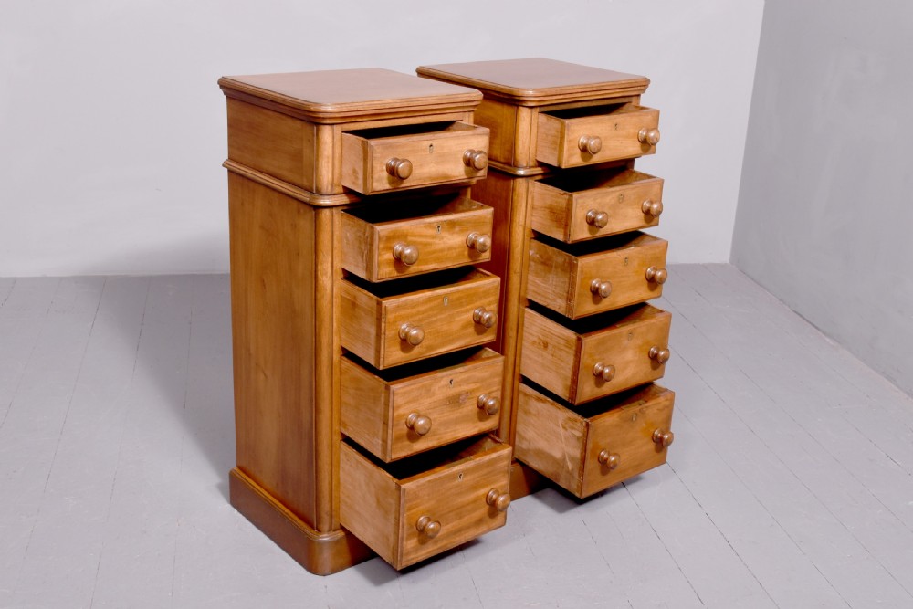 A pair of tall Victorian mahogany Wellington-style chests, each featuring five stacked drawers with turned wood knobs and stepped plinth bases. View II