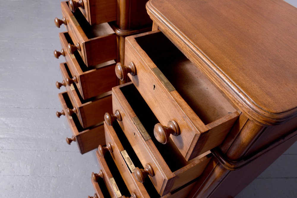 A pair of tall Victorian mahogany Wellington-style chests, each featuring five stacked drawers with turned wood knobs and stepped plinth bases. View III