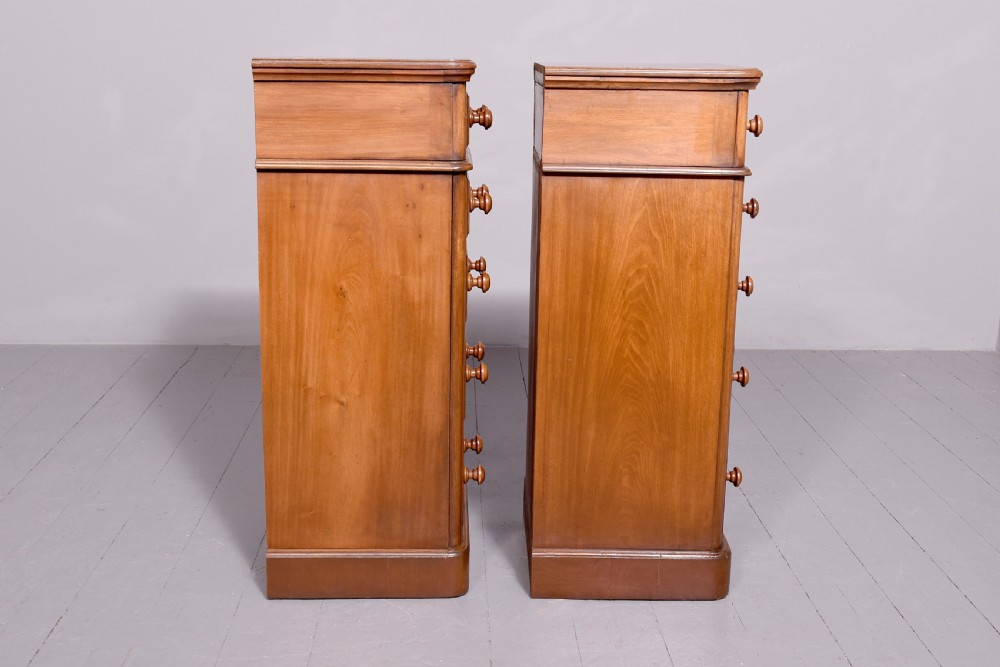 A pair of tall Victorian mahogany Wellington-style chests, each featuring five stacked drawers with turned wood knobs and stepped plinth bases. View VII