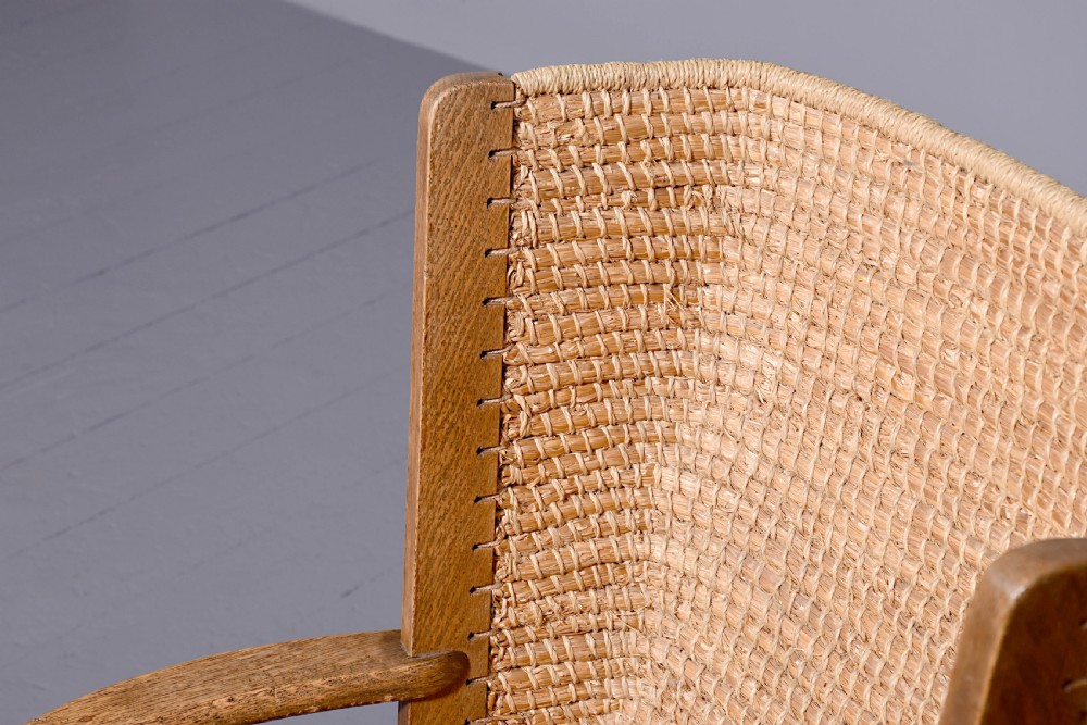 An oak armchair featuring a tall woven straw backrest, flat open armrests, and a rush seat. View IV