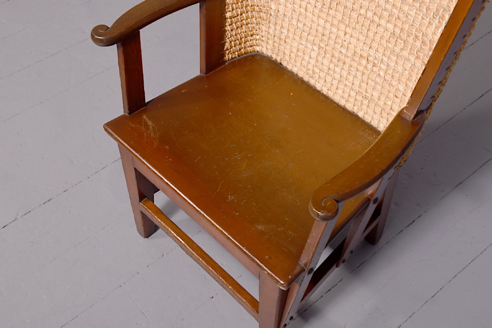 A stained beech wood armchair featuring a high curved backrest hand-woven from natural straw, a flat wooden seat, and open armrests. View IV