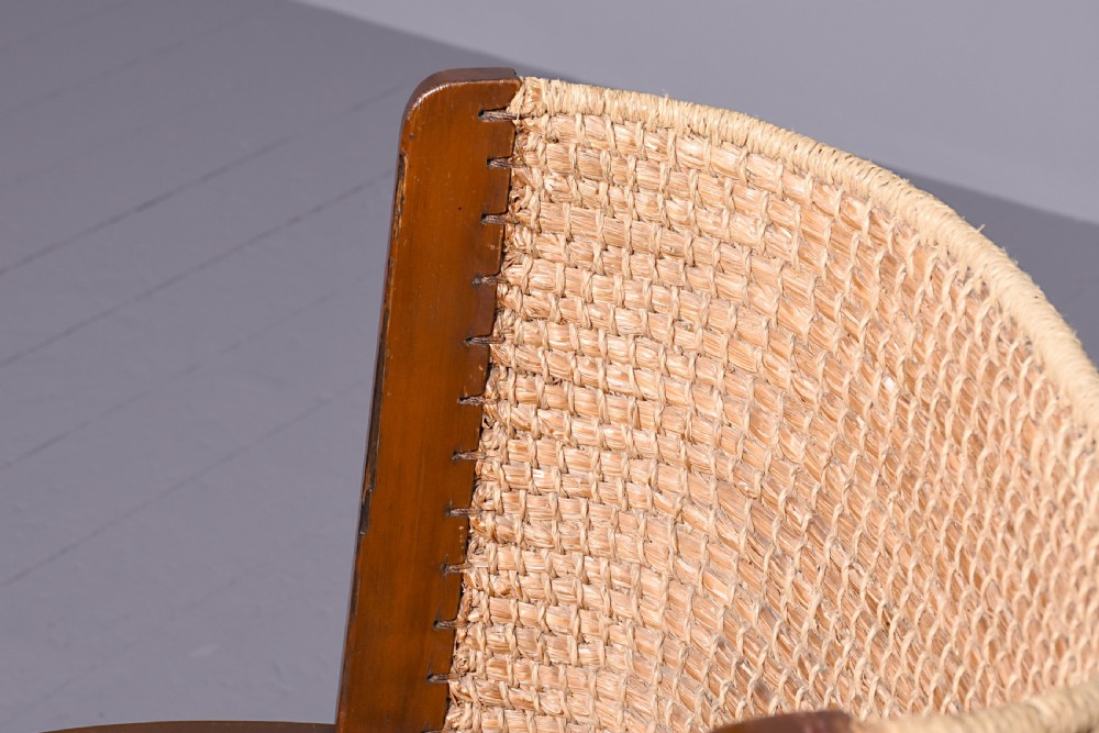 A stained beech wood armchair featuring a high curved backrest hand-woven from natural straw, a flat wooden seat, and open armrests. View V