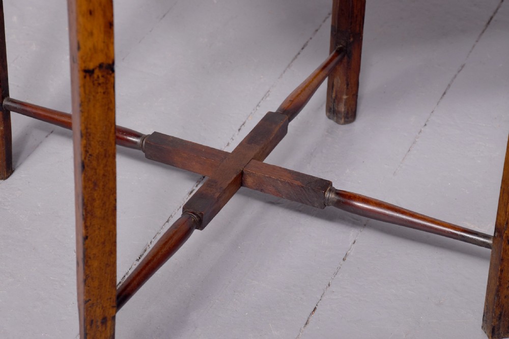 A square two-tier mahogany occasional table featuring slender uprights, a scalloped frieze detail, and a cross-stretcher base. View II