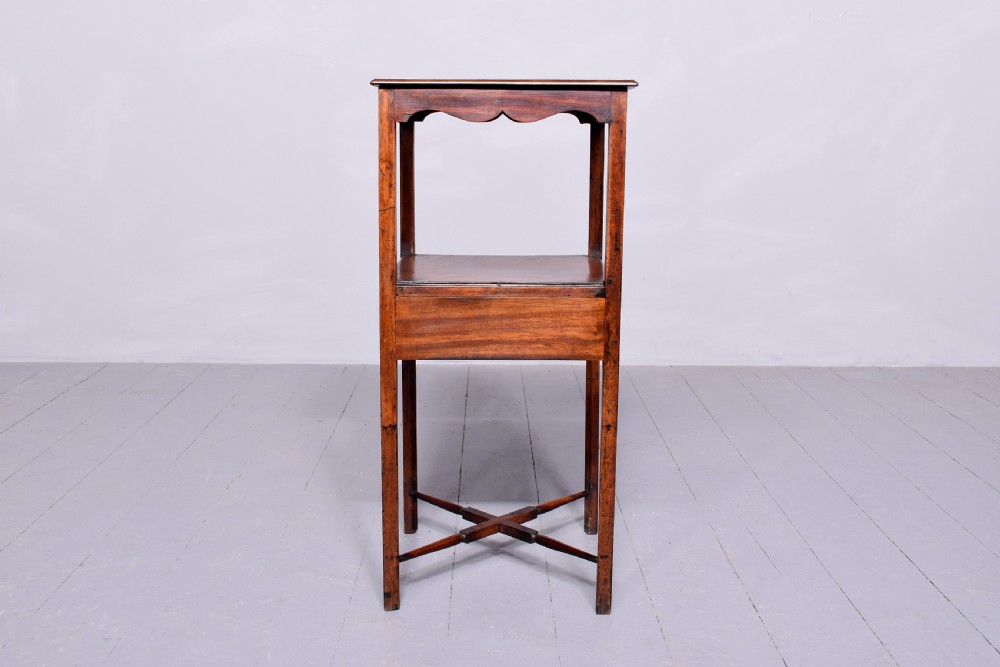 A square two-tier mahogany occasional table featuring slender uprights, a scalloped frieze detail, and a cross-stretcher base. View V