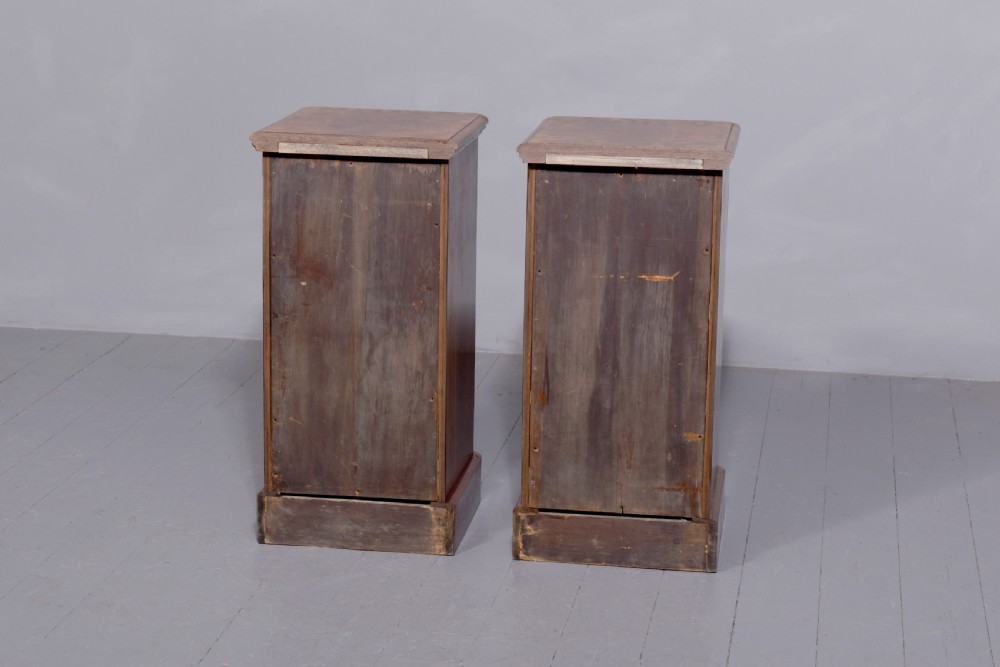 A pair of late Victorian burr walnut small chests of drawers featuring four drawers each with brass handles and plinth bases. View IV