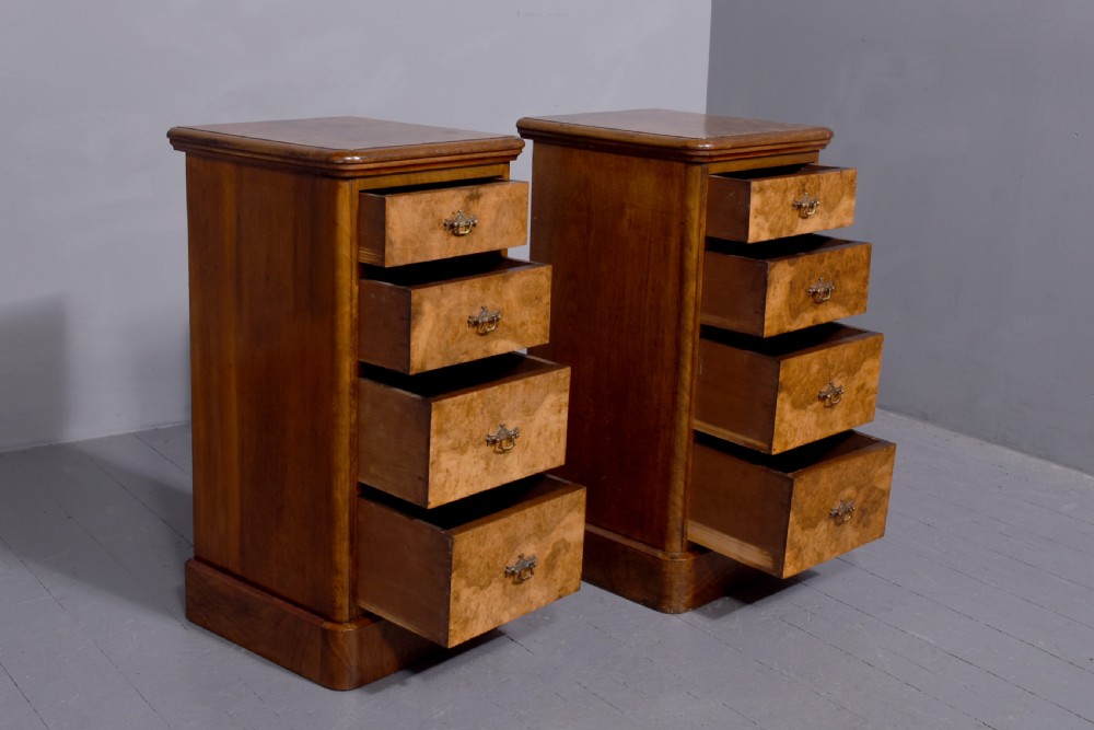 A pair of late Victorian burr walnut small chests of drawers featuring four drawers each with brass handles and plinth bases. View VI