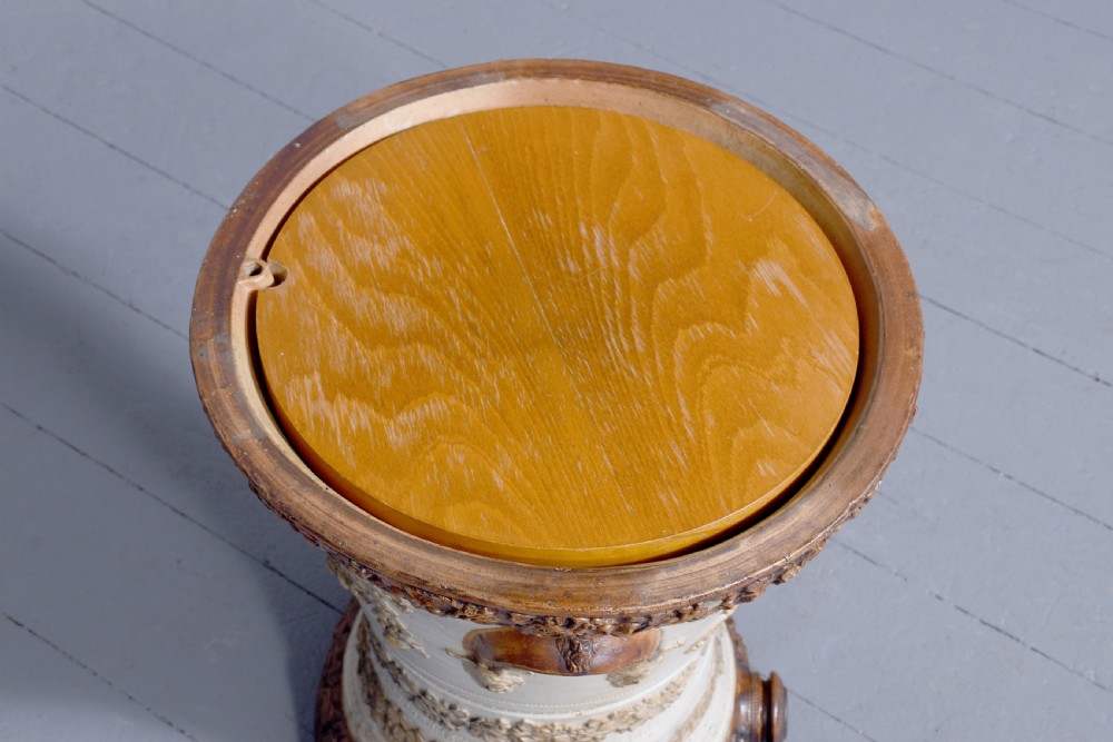 A Victorian glazed stoneware water filter urn decorated with relief crest motifs, floral borders, side handles, and a fitted wooden lid. View IX