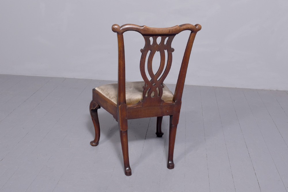 A George II carved mahogany side chair featuring a pierced strapwork splat back, green velvet seat, and cabriole front legs with pad feet. View II