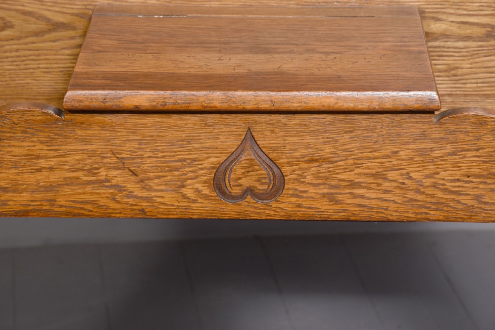 An antique oak Art Nouveau hall stand featuring a central mirror, brass coat hooks, a small shelf compartment, and a lower umbrella stand base. View XI