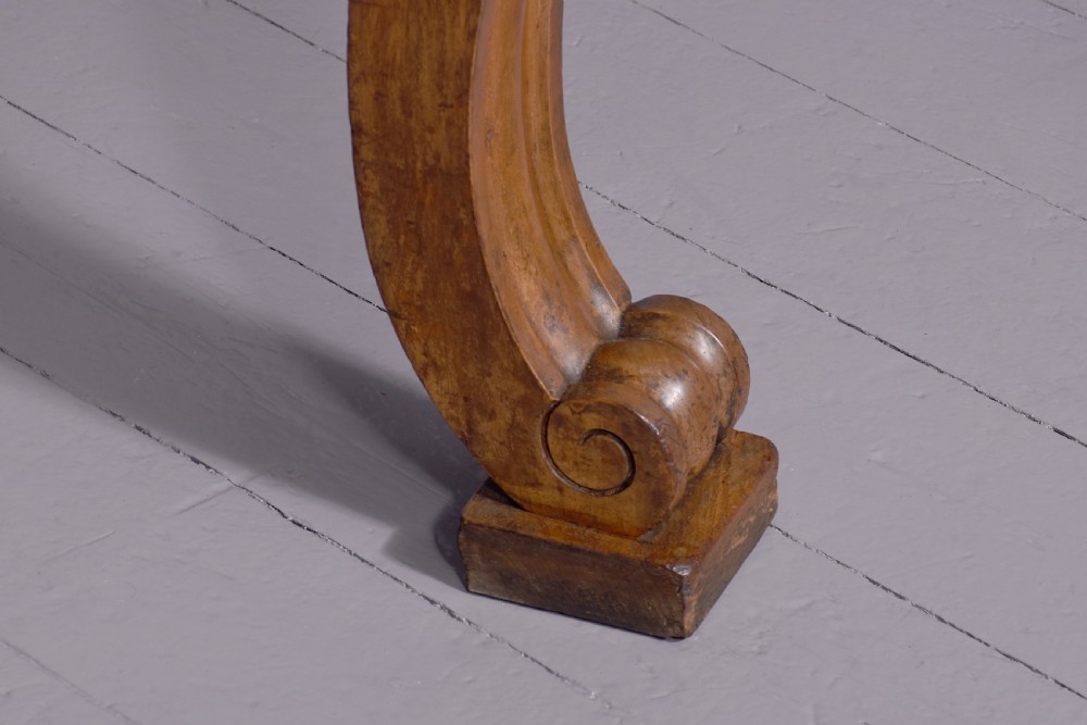 A William IV mahogany console table featuring a pedimented upstand, flame mahogany frieze, and acanthus leaf carved scroll front legs resting on plinth bases. View II