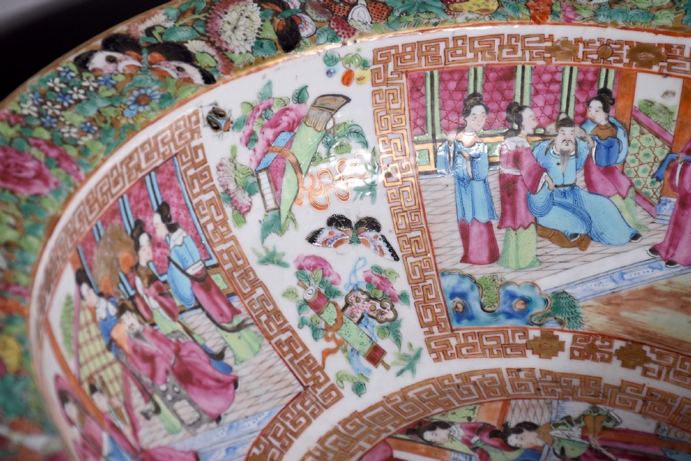 A large round Canton Famille Rose porcelain bowl decorated inside with hand-painted Mandarin figure scenes, floral borders, and gilded rims. View II
