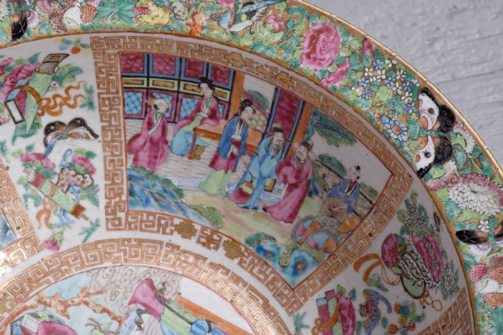 A large round Canton Famille Rose porcelain bowl decorated inside with hand-painted Mandarin figure scenes, floral borders, and gilded rims. View IV