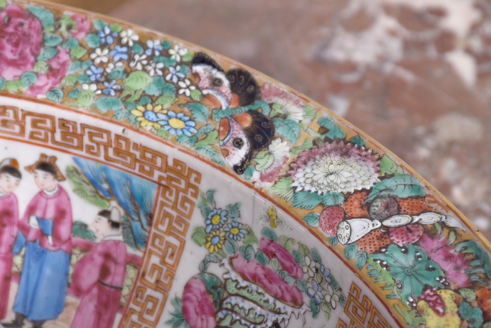 A large round Canton Famille Rose porcelain bowl decorated inside with hand-painted Mandarin figure scenes, floral borders, and gilded rims. View VIII