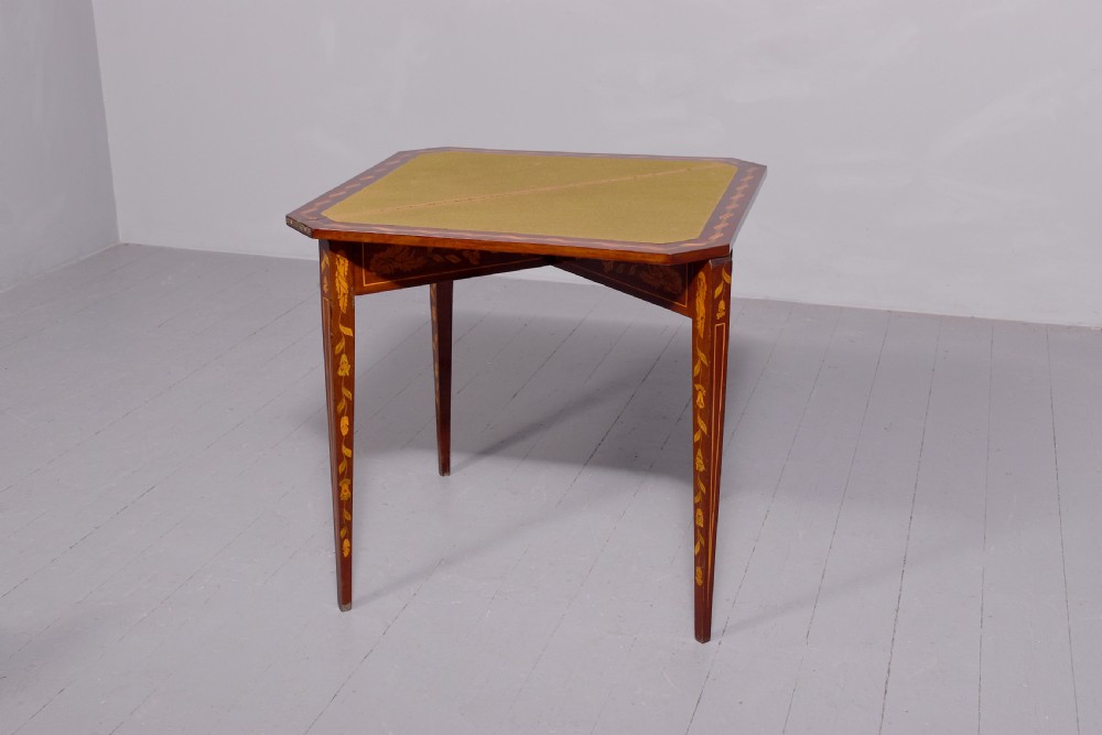 A triangular wooden Dutch card table featuring detailed floral marquetry inlay on the top surface and tapered square legs. View VI