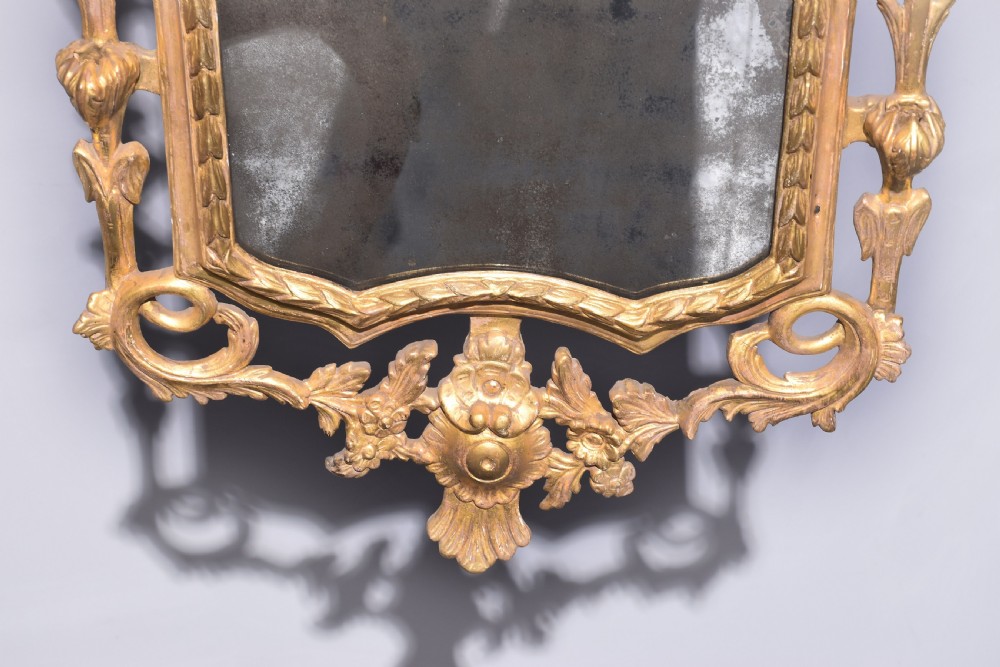 A late 18th-century Neoclassical giltwood wall mirror with a carved ribbon crest, profile medallion, and side foliate columns. View IV