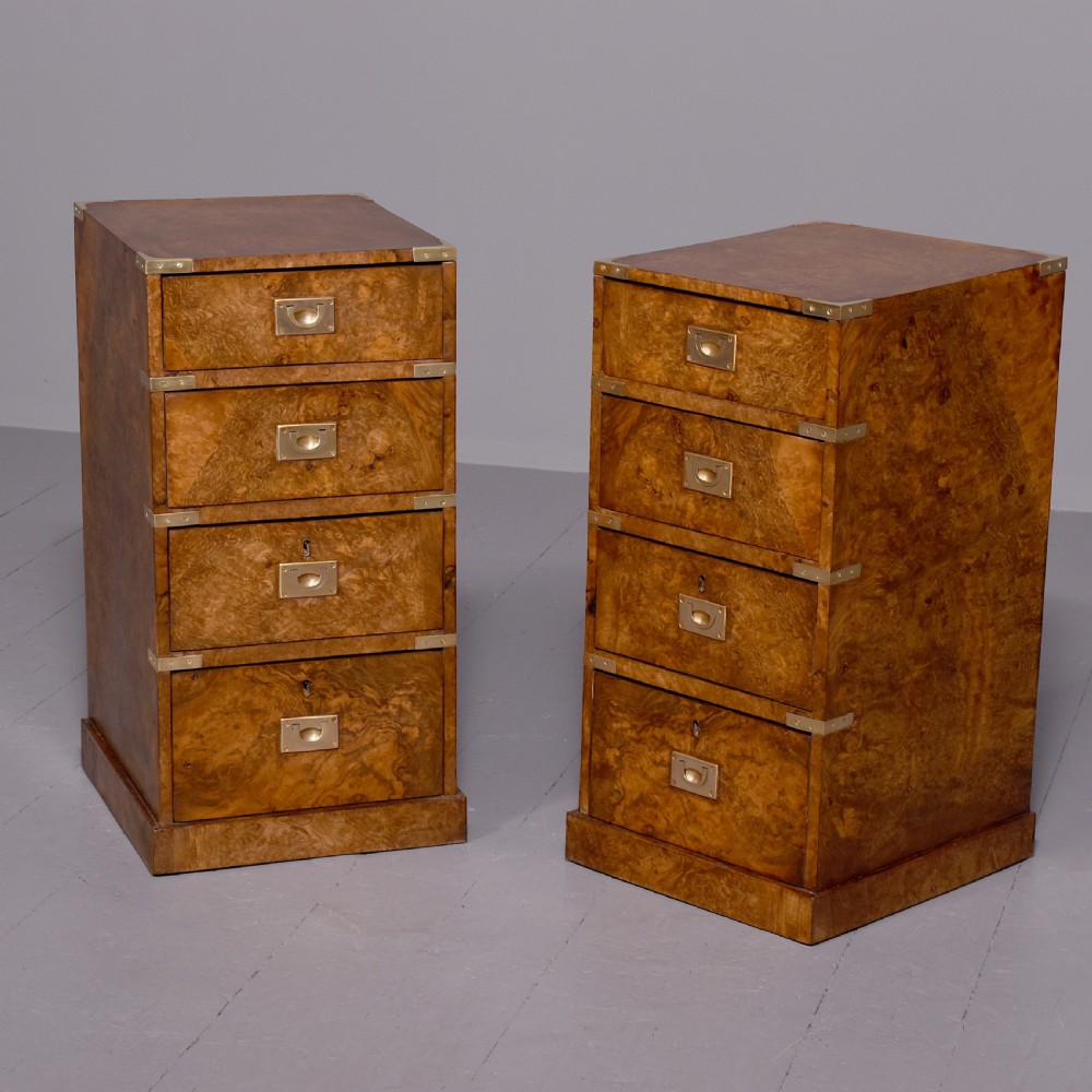 A pair of Victorian burr walnut military style small chests of drawers featuring flush brass handles, corner brackets, and four graduated drawers.