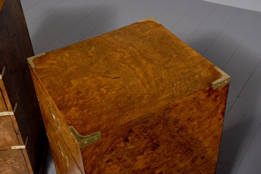 A pair of Victorian burr walnut military style small chests of drawers featuring flush brass handles, corner brackets, and four graduated drawers. View II