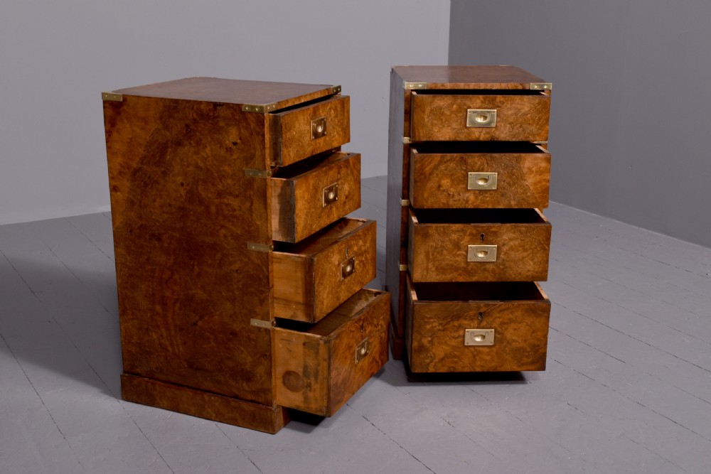 A pair of Victorian burr walnut military style small chests of drawers featuring flush brass handles, corner brackets, and four graduated drawers. View V