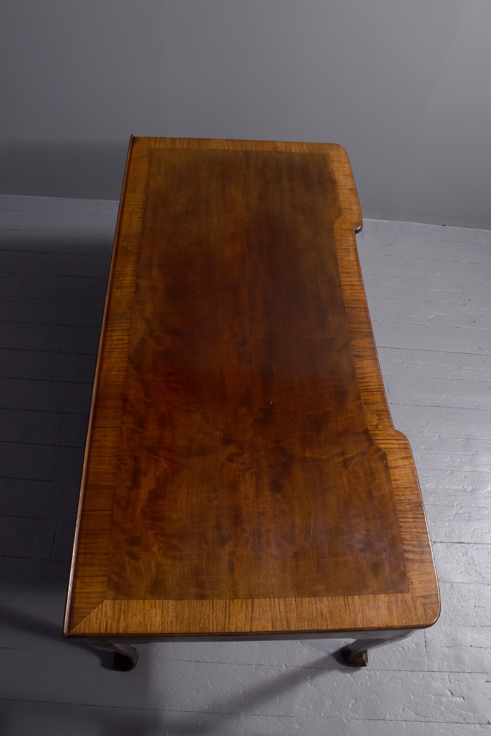 A large crossbanded mahogany library desk featuring three frieze drawers and slender cabriole legs. View III