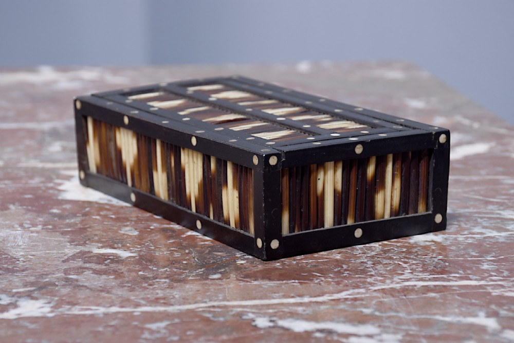 An Edwardian rectangular porcupine quill box with dark ebonised wooden framing and circular bone dot inlays. View V
