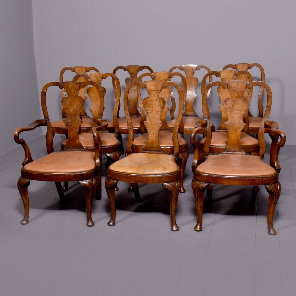 A set of ten George II walnut dining chairs with vasiform back splats, leather upholstery, and cabriole legs.