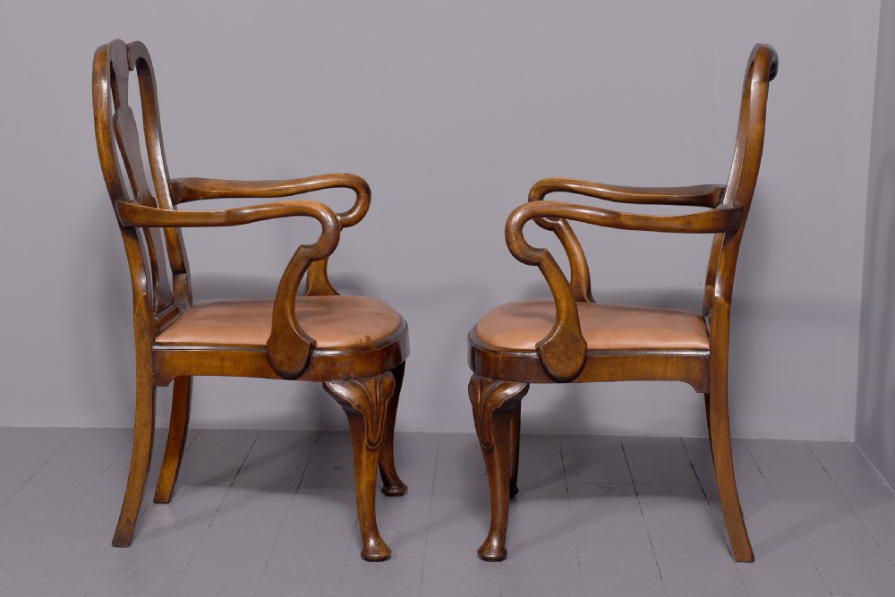 A set of ten George II walnut dining chairs with vasiform back splats, leather upholstery, and cabriole legs. View V