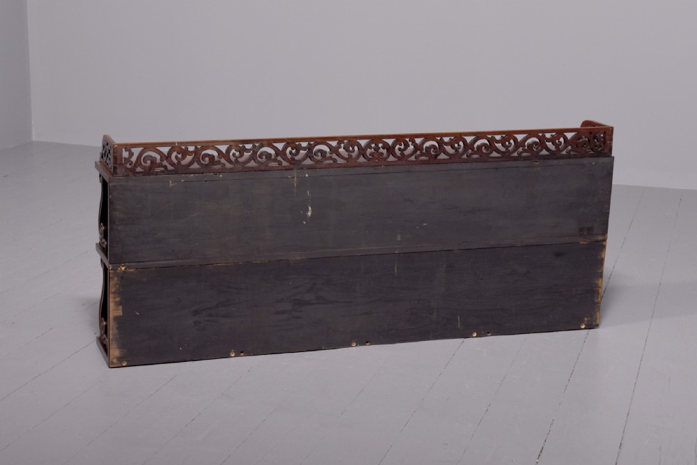 A three-tier William IV dark rosewood wall shelf featuring open shelving, curved S-scroll side supports, and a pierced fretwork top gallery rail. View II