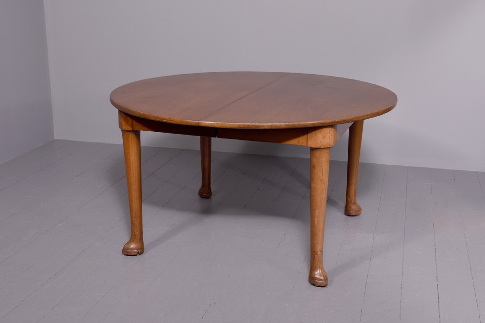 An oval antique timber extending dining table with tapered legs and sculpted pad feet. View V