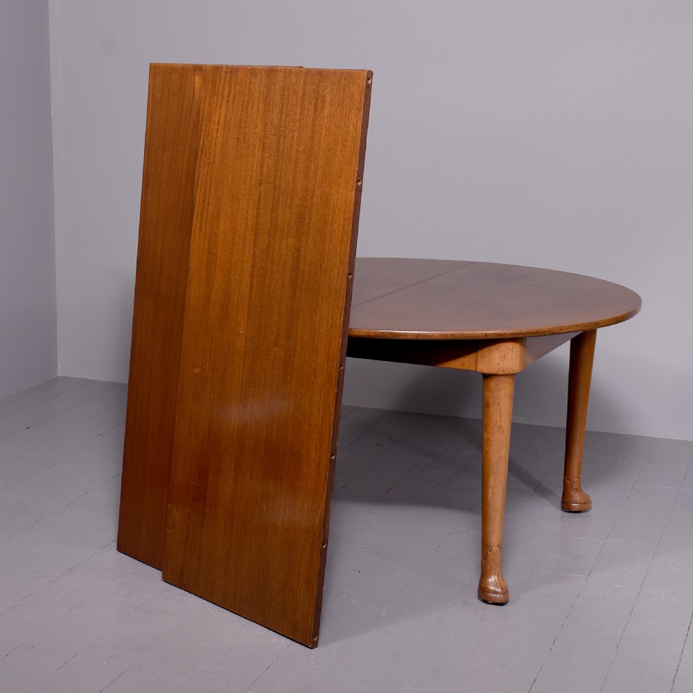 An oval antique timber extending dining table with tapered legs and sculpted pad feet. View VII