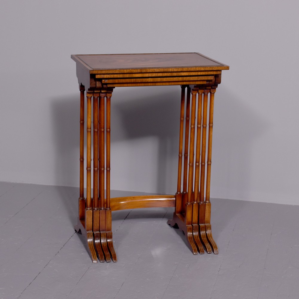 A set of four nested mahogany quartetto tables featuring rectangular crossbanded tops and slender turned legs.