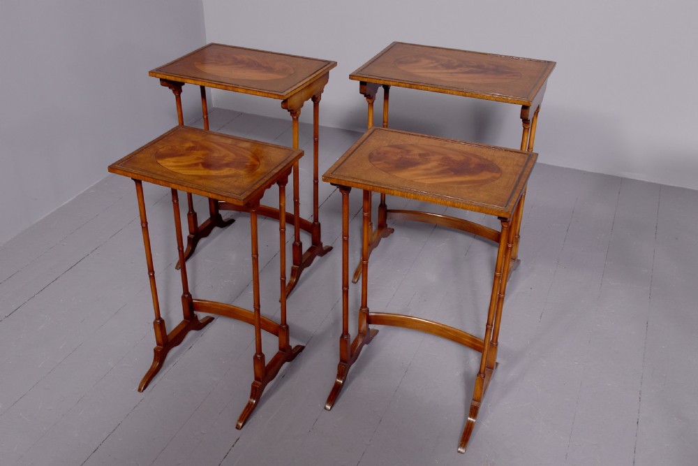 A set of four nested mahogany quartetto tables featuring rectangular crossbanded tops and slender turned legs. View VI