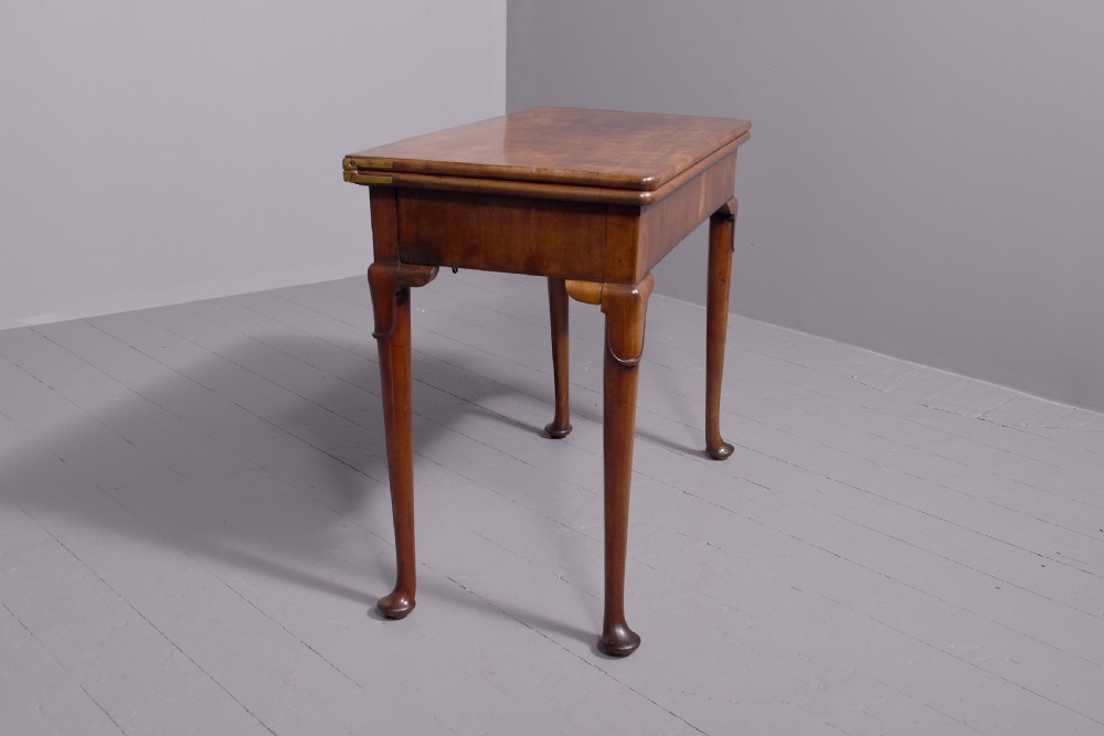 A George II mahogany card table featuring a rectangular fold-over top and slender cabriole legs terminating in pad feet. View VII