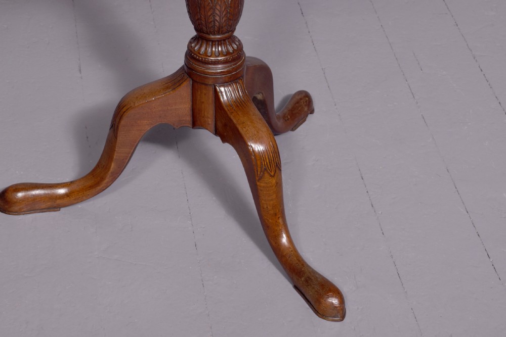 A George III mahogany occasional table featuring a circular top raised on a fluted central pedestal and a tripod base with carved cabriole legs. View II