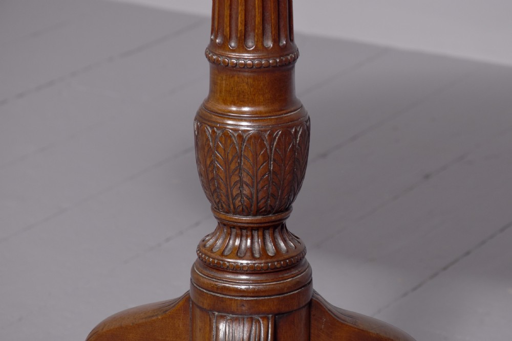 A George III mahogany occasional table featuring a circular top raised on a fluted central pedestal and a tripod base with carved cabriole legs. View IV