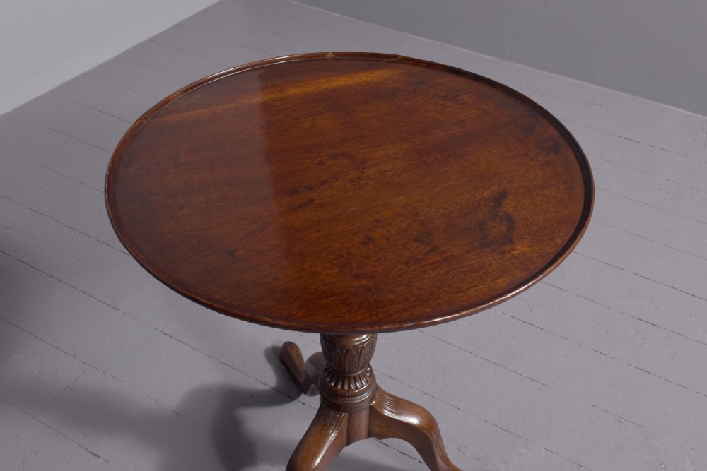 A George III mahogany occasional table featuring a circular top raised on a fluted central pedestal and a tripod base with carved cabriole legs. View V