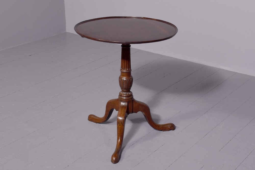 A George III mahogany occasional table featuring a circular top raised on a fluted central pedestal and a tripod base with carved cabriole legs. View VI