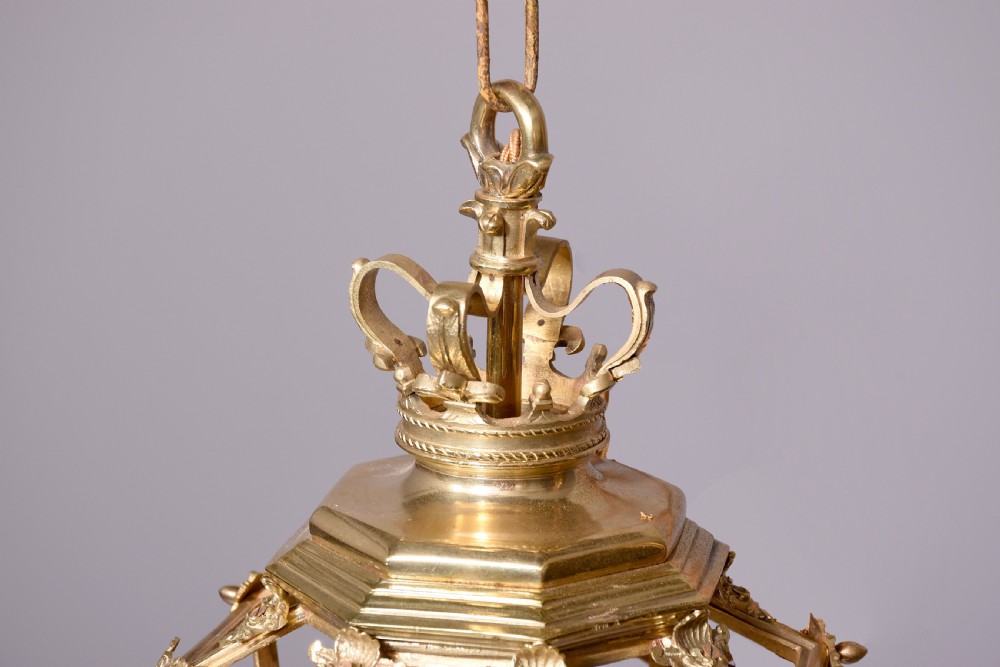 A French hexagonal ormolu ceiling lantern featuring ornate leaf scrollwork, a top crown canopy, and a suspended chain fitting. View VI